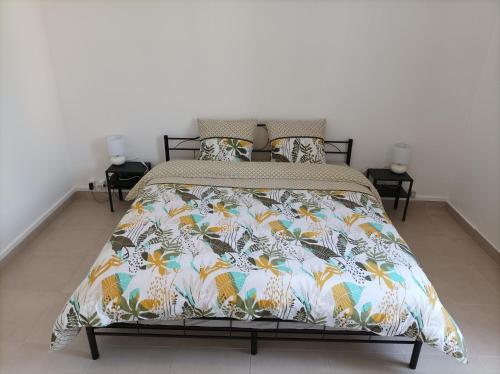 a bedroom with a bed with a colorful comforter at O'Couvent - Appartement 77 m2 - 2 chambres - A321 in Salins-les-Bains