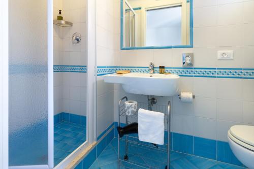 a blue and white bathroom with a sink and a toilet at B&B Sperlonga in Sperlonga