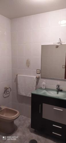 y baño con lavabo, aseo y espejo. en Apartamentos xistra, en Cangas del Narcea
