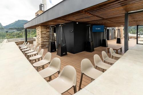 a row of white chairs in front of a building at CentralX 21 Bogotá in Bogotá