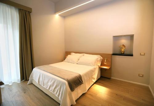 a bedroom with a white bed and a window at ACANTO -Viaggio Barocco in Ragusa