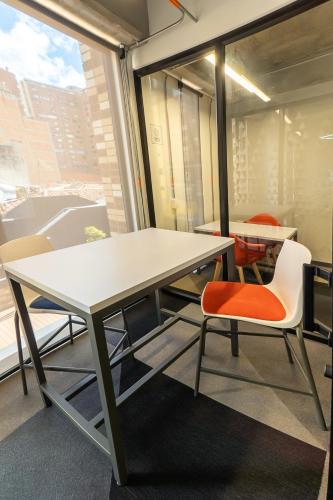 a table and chairs in a room with a window at CentralX 21 Bogotá in Bogotá