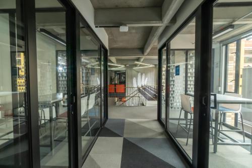 a hallway with glass doors and a table and chairs at CentralX 21 Bogotá in Bogotá