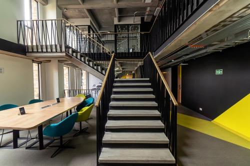 a staircase with a table and chairs in a room at CentralX 21 Bogotá in Bogotá