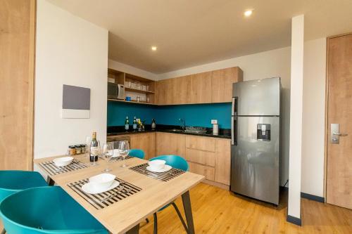 a kitchen with a wooden table and a refrigerator at CentralX 21 Bogotá in Bogotá