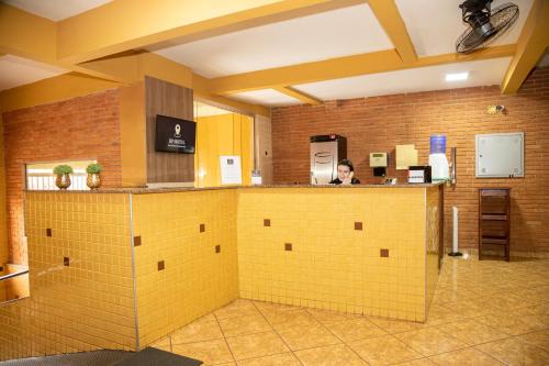 a man is standing at a counter in a kitchen at RP HOTEL in Ribeirão Preto