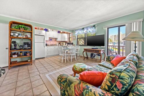 a living room with a couch and a kitchen at Majestic Beach Condo with Heated POOL in St Pete Beach in St Pete Beach