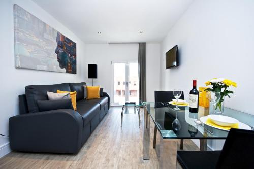 a living room with a couch and a glass table at Staycity Aparthotels Deptford Bridge Station in London