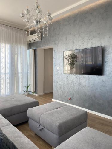 a living room with two beds and a chandelier at Apartment Lana in Baška Voda