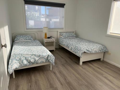 a bedroom with two beds and a window at Shellharbour. Ocean, lake and mountain view in Shellharbour