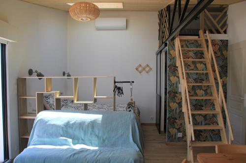 een slaapkamer met een bed en een ladder in een kamer bij Maison Ti Havre avec jardin privé dans village de pêcheurs à Brem sur mer ! in Brem-Sur-Mer