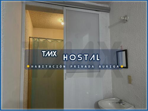 La salle de bains est pourvue d'un lavabo blanc et d'un miroir. dans l'établissement TMX HOSTAL, à Puerto Escondido