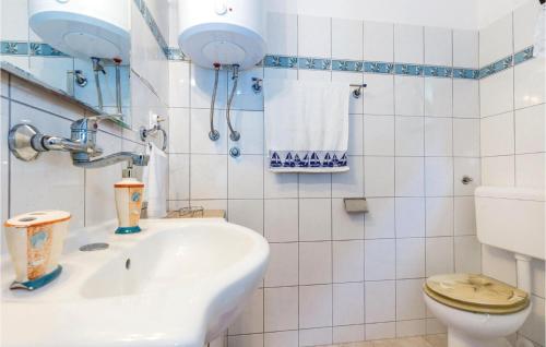La salle de bains blanche est pourvue de toilettes et d'un lavabo. dans l'établissement 2 Bedroom Gorgeous Apartment In Jadranovo, à Jadranovo