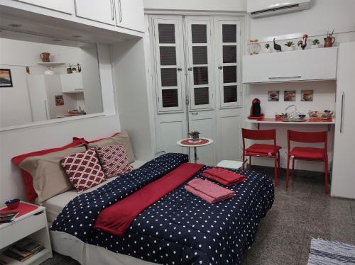 a small bedroom with a bed and a kitchen at Charmoso Studio Ipanema in Rio de Janeiro