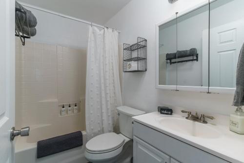 een witte badkamer met een toilet en een wastafel bij Desert Twilight 29 - Hot Tub & EV Charger in Twentynine Palms