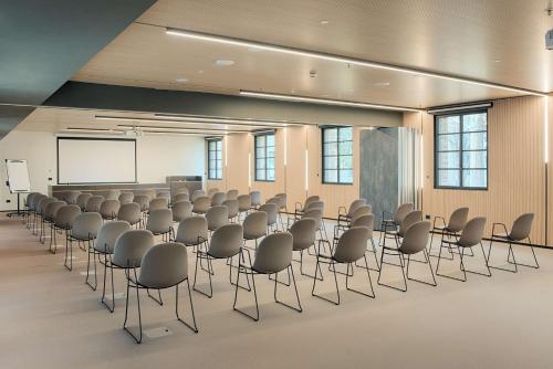 a conference room with chairs and a whiteboard at NH Collection Murano Villa in Murano