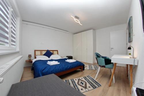 a bedroom with a blue bed and a desk at Apartment Magnolia Old Town in Sarajevo