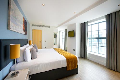 a bedroom with a large bed and a large window at Staycity Aparthotels Deptford Bridge Station in London