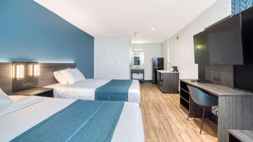 a hotel room with two beds and a desk at Studio 6 Suites Stockton, CA Waterfront in Stockton
