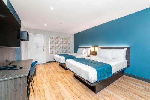 a hotel room with two beds and a blue wall at Studio 6 Suites Stockton, CA Waterfront in Stockton