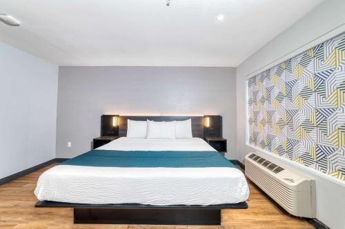 a bedroom with a bed and a painting on the wall at Studio 6 Suites Stockton, CA Waterfront in Stockton