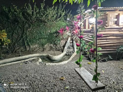 a snake laying on the ground next to a house at Paraiso Hortensia Ecolodge in Santiago de los Caballeros