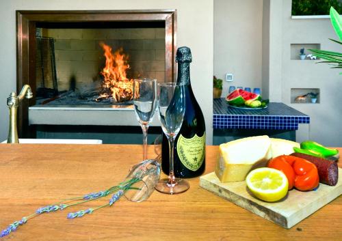 a table with two wine glasses and a bottle of wine at Villa Bougenvilia Tomas in Tučepi