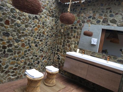 a stone bathroom with a sink and a mirror at leremita biohotel in Silvia