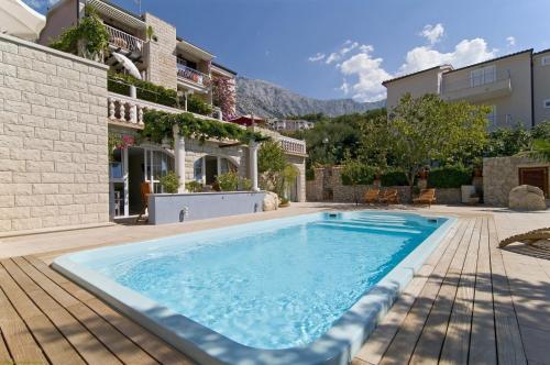 a swimming pool in the yard of a house at Villa Bougenvilia Tomas in Tučepi