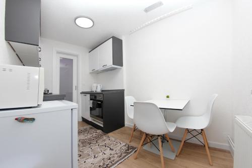 a kitchen with a white table and white chairs at Apartment Magnolia Old Town in Sarajevo