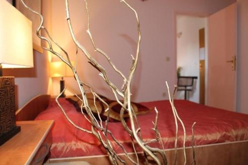 a bedroom with a bed with a branch on it at Villa Bougenvilia Tomas in Tučepi