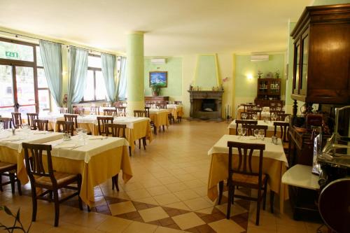 un ristorante con tavoli, sedie e un camino di Park Hotel La Pineta a Mulazzo