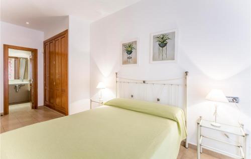 アルコセブレにあるNice Apartment In Alcossebre With 2 Bedrooms, Wifi And Outdoor Swimming Poolの緑のベッドと壁に2枚の絵が飾られたベッドルーム1室が備わります。