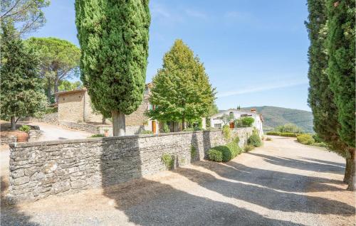 a stone wall with trees and a house at 2 Bedroom Lovely Home In Loro Ciuffenna in Loro Ciuffenna