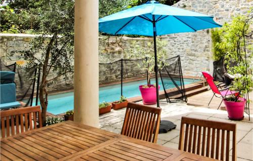 - une table avec un parasol bleu et des chaises à côté de la piscine dans l'établissement Lovely Home In Villeneuve De Berg, à Montboucher-sur-Jabron