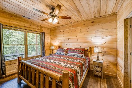 a log cabin bedroom with a bed and a ceiling fan at Mountain View Retreat in Cherry Log