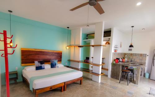 a bedroom with a large bed and a kitchen at Les Suites Calle 2 by Galian in Tulum