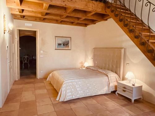 a bedroom with a large bed and a staircase at Palazzo Laureano - Dimora Storica in Tricarico