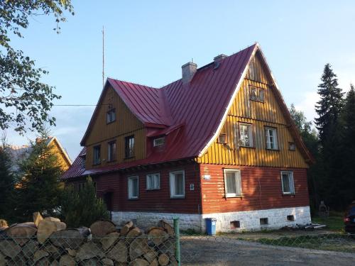 a large wooden house with a red roof at Strażnica Pod Lasem in Lasowka