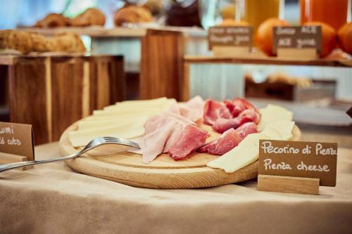 a bunch of meat on a cutting board on a table at Hotel Corsignano in Pienza