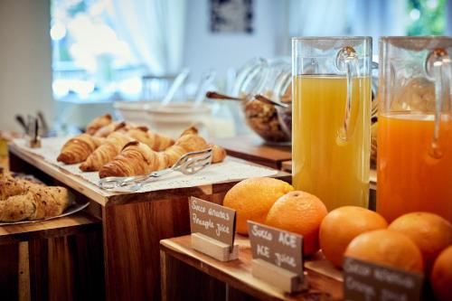 a buffet with bread and oranges and orange juice at Hotel Corsignano in Pienza