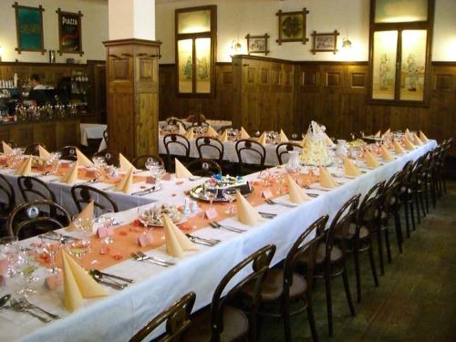 ブルノにあるRestaurant Švejk a Pension Brnoのテーブルと椅子付きの部屋内の長テーブル