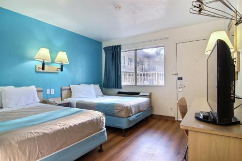 een hotelkamer met 2 bedden en een flatscreen-tv bij Motel 6-Lubbock, TX in Lubbock