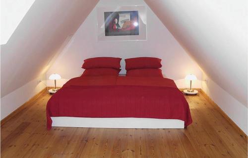 1 dormitorio con 1 cama con sábanas rojas y 2 lámparas en 3 Bedroom Amazing Apartment In Altenmedingen, en Altenmedingen