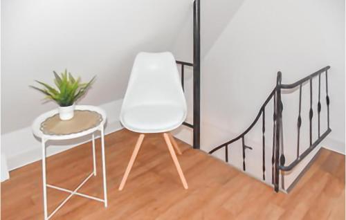 uma cadeira branca, uma mesa e uma planta em 1 Bedroom Cozy Home In Bad Doberan em Bad Doberan