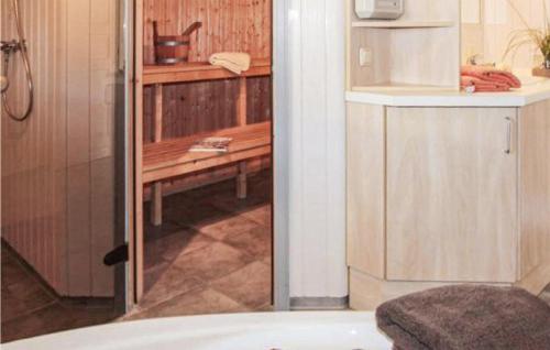 een badkamer met een douche en een keuken met een koelkast bij 2 Bedroom Gorgeous Home In Rechlin in Rechlin