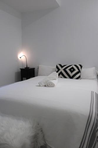 a white bed with two pillows on top of it at Masia Sagués in Poblet