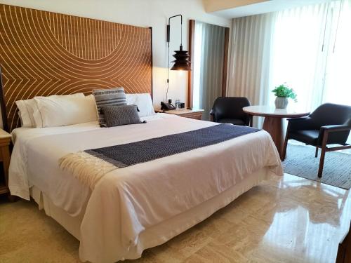 a bedroom with a large bed and a table and chairs at Fiesta Americana Puerto Vallarta All Inclusive & Spa in Puerto Vallarta