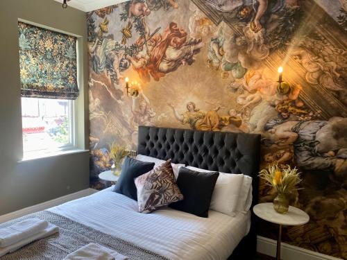 a bedroom with a painting on the wall at Lletty by Orenda-Luxe in Llandudno