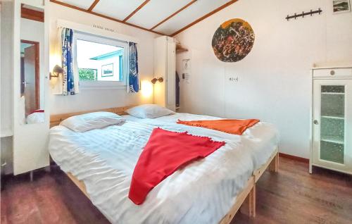una camera da letto con un grande letto con una coperta rossa sopra di Calimero a Sint Annaland